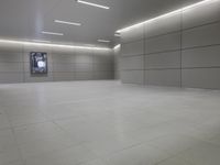 a white floor has tile and lights lit by recesses in an empty room on the wall