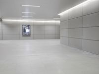 a white floor has tile and lights lit by recesses in an empty room on the wall