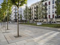 a very nice walkway outside of some very pretty buildings in europe area, with trees