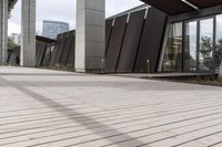 a sidewalk leading up to a building with a few columns and walkways that lead up to it