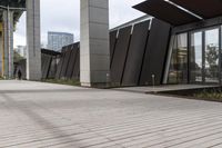 a sidewalk leading up to a building with a few columns and walkways that lead up to it