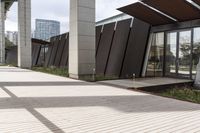 a sidewalk leading up to a building with a few columns and walkways that lead up to it