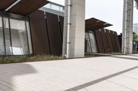 a sidewalk leading up to a building with a few columns and walkways that lead up to it