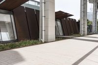 a sidewalk leading up to a building with a few columns and walkways that lead up to it