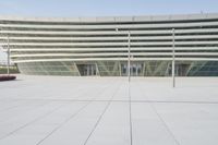 people walking around outside of a building on a sunny day of the day with lots of glass