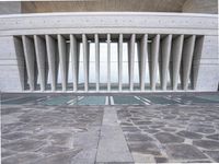 a building with many columns and pillars, made of concretes, has a stone floor and ceiling