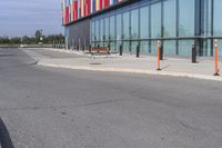 a red stop sign is at the end of an empty sidewalk and outside a building