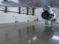 a plane sitting inside of a building in the middle of an empty garage floor next to a staircase