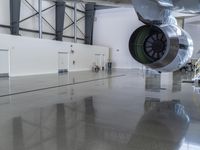 a plane sitting inside of a building in the middle of an empty garage floor next to a staircase