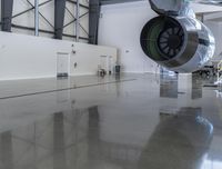 a plane sitting inside of a building in the middle of an empty garage floor next to a staircase