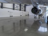 a plane sitting inside of a building in the middle of an empty garage floor next to a staircase