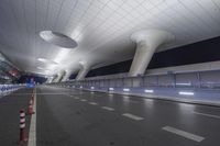 a wide open space with modern lighting and a modern airport looking building on both sides