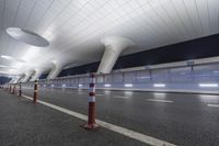 a wide open space with modern lighting and a modern airport looking building on both sides