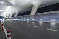 a wide open space with modern lighting and a modern airport looking building on both sides