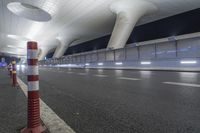 a wide open space with modern lighting and a modern airport looking building on both sides