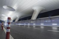 a wide open space with modern lighting and a modern airport looking building on both sides