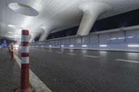 a wide open space with modern lighting and a modern airport looking building on both sides