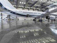 a plane sits in a large hanger at the airport while being serviced for service