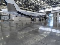 a plane sits in a large hanger at the airport while being serviced for service