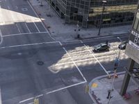 a couple cars are going by a tall building and some buildings that have been constructed around it