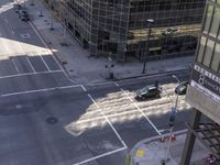 a couple cars are going by a tall building and some buildings that have been constructed around it