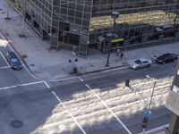 a couple cars are going by a tall building and some buildings that have been constructed around it