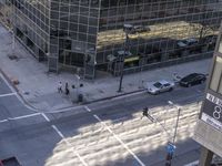 a couple cars are going by a tall building and some buildings that have been constructed around it