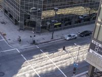 a couple cars are going by a tall building and some buildings that have been constructed around it