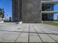 a building with a large brick walkway next to it and grass on the ground below