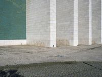 a fire hydrant sitting on top of a cement parking lot near a building's green door