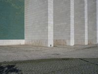 a fire hydrant sitting on top of a cement parking lot near a building's green door