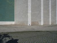 a fire hydrant sitting on top of a cement parking lot near a building's green door