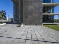 a building with a parking meter on the pavement next to it and some grass on both sides