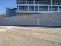 an open building with windows and walls that has a skateboarder on it walking