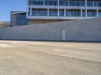 an open building with windows and walls that has a skateboarder on it walking