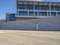 an open building with windows and walls that has a skateboarder on it walking