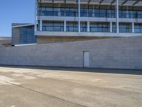 an open building with windows and walls that has a skateboarder on it walking