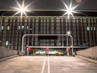 a car is parked under streetlights and a parking garage for cars with no passengers