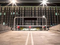 a car is parked under streetlights and a parking garage for cars with no passengers