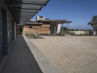 modern architecture in the desert with mountains and a blue sky in the background and the sidewalk to the right