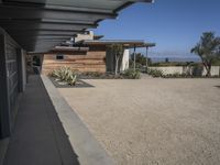 modern architecture in the desert with mountains and a blue sky in the background and the sidewalk to the right