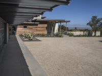 modern architecture in the desert with mountains and a blue sky in the background and the sidewalk to the right