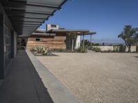 modern architecture in the desert with mountains and a blue sky in the background and the sidewalk to the right