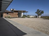 modern architecture in the desert with mountains and a blue sky in the background and the sidewalk to the right