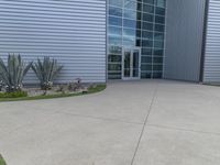 two men are walking past a building with large windows and grass around the door,
