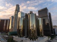 the buildings in the city are near the highway by it are tall with a lot of glass and concrete