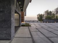 the exterior and landscape of a modern house in los angeles, california with stone and wood