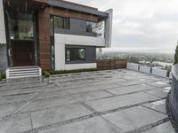 a large gray patio that is outside of a house with concrete floors and walls, and stone paving