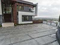 a large gray patio that is outside of a house with concrete floors and walls, and stone paving