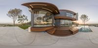 a circular building with a very large patio area outside it's glass doors open